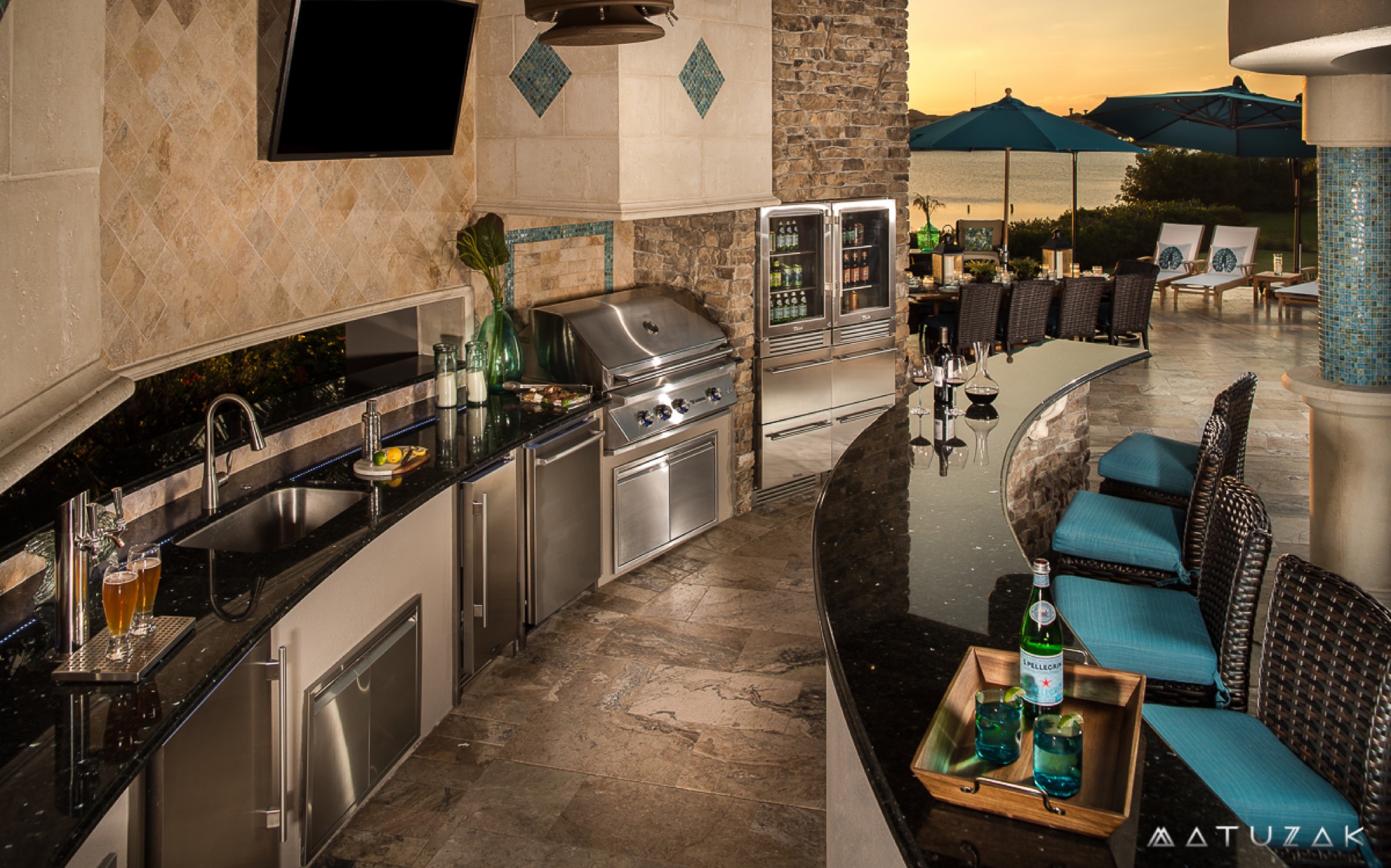 Outdoor seating and umbrellas furnished by Patio Style overlooking the water