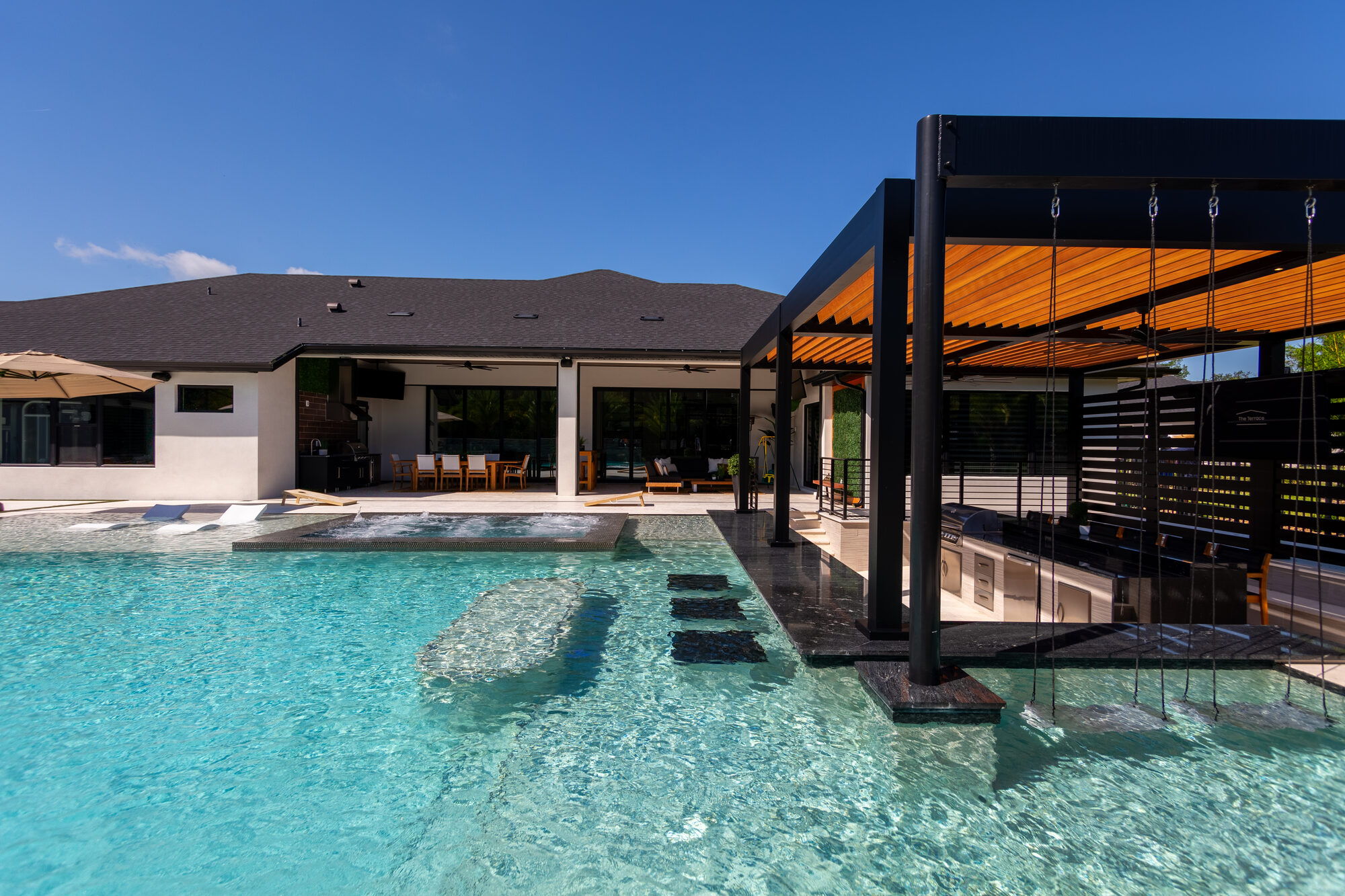 Black aluminum louvered pergola over the pool deck in New Smyrna Beach, FL