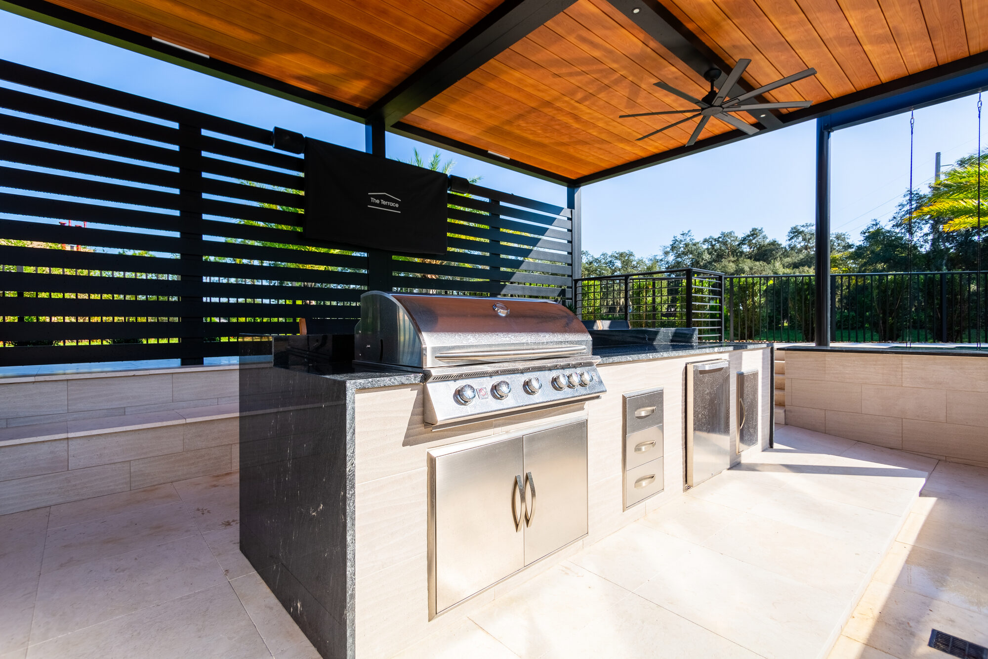 Freestanding black aluminum pergola set on the pool deck in New Smyrna Beach, FL