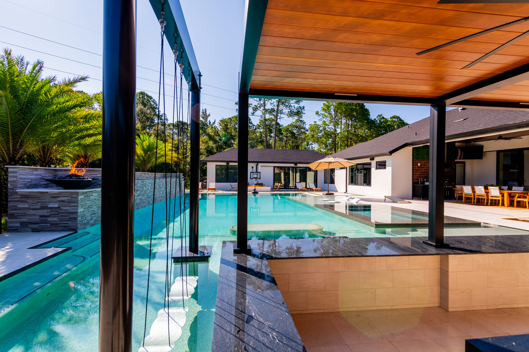 Louvered pergola integrated into the poolside patio in Turnbull Crossings, New Smyrna Beach, FL