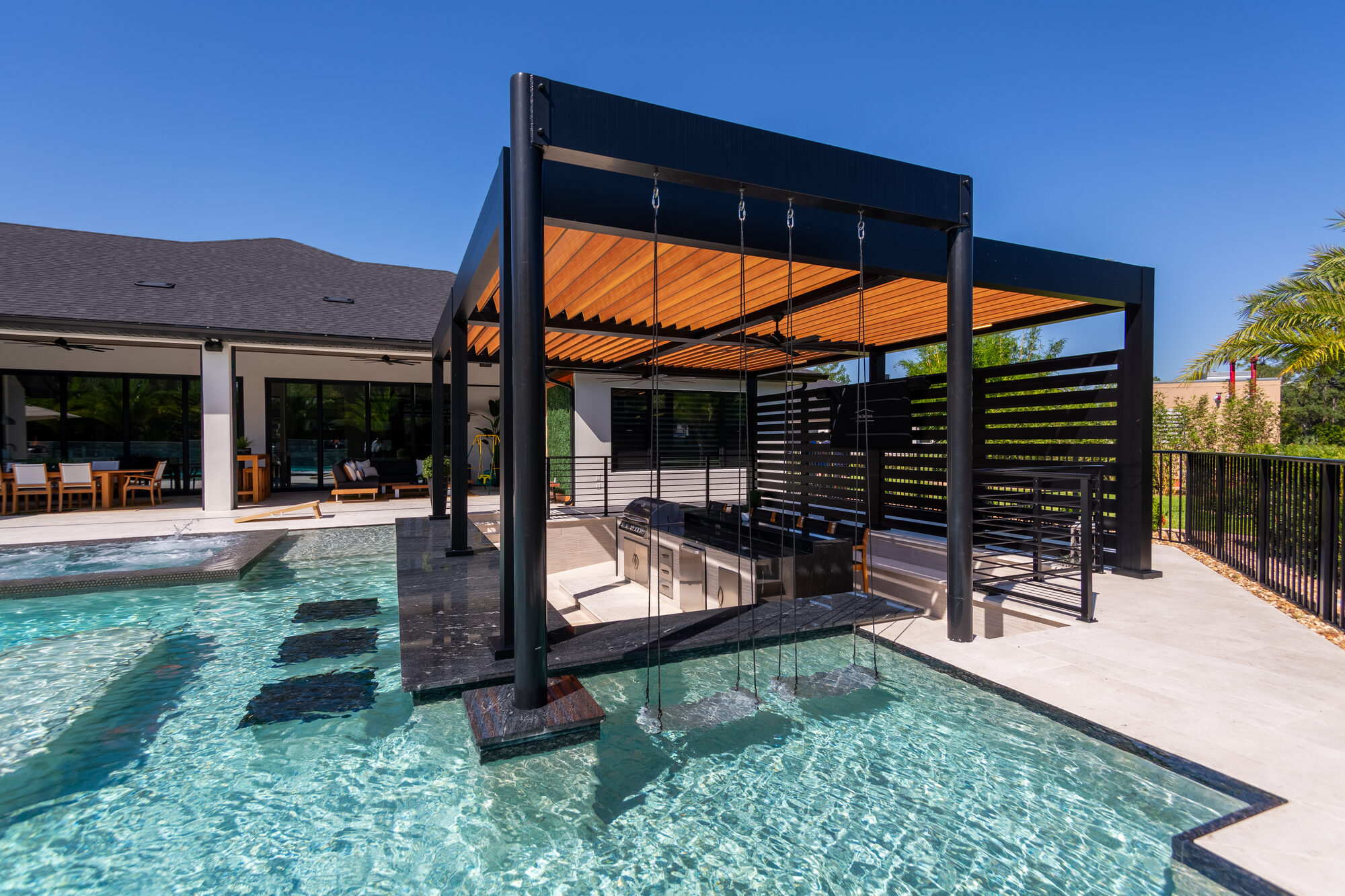 Black aluminum louvered pergola over the pool deck in New Smyrna Beach, FL